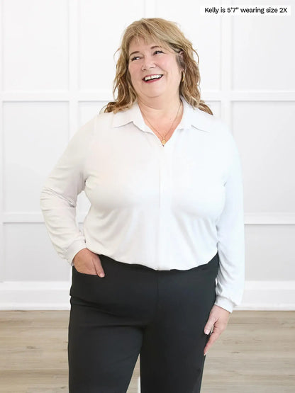 Woman wearing a white blouse and black pants against a white background 