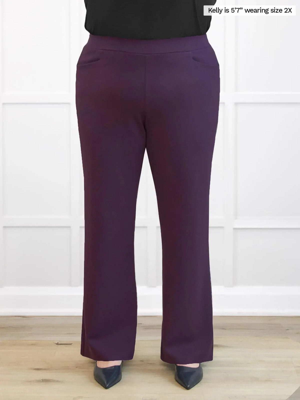 Purple pants worn by a person on a white background 