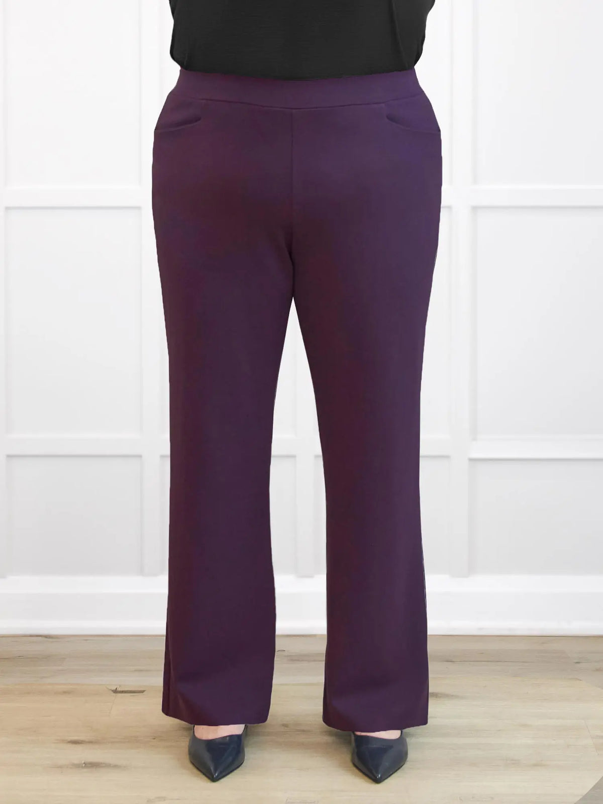 Purple pants worn by a person on a white background