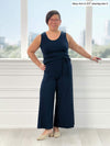 Miik model Mary-Ann (5'0", small, petite) smiling wearing Miik's Kimmay open-back capri jumpsuit in navy