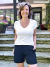 Miik founder Donna (5'6", small) smiling wearing Miik's Leland everyday dressy short in navy with a v-neck tee in white 