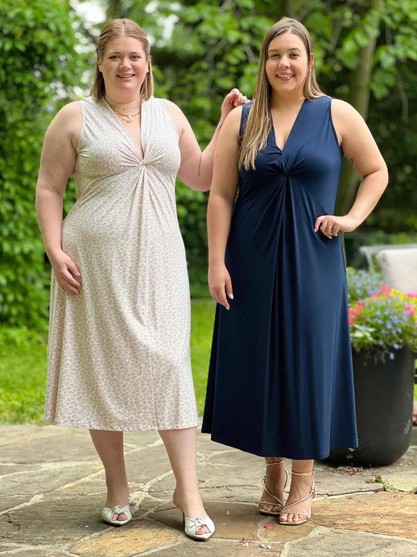 Miik models Bri and Christal standing next to each other smiling while both wearing Miik's Lina midi knot dress in cobblestone and navy