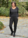 Miik founder Donna (5'6", small) smiling and looking away wearing an all charcoal comfy outfit: Miik's Linaya luxe fleece jogger and Priya v-neck long sleeve top