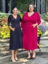 Miik models Meron and Sarita smiling both wearing Miik's Lolly midi flounce dress with pockets. Meron is wearing size xsmall in the colour navy, while Sarita is wearing size 3x in bordeaux 