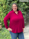 Miik model plus size Sarita (5'7", size 2x) smiling wearing Miik's Lucia collared shirt in bordeaux with jeans