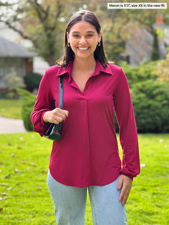 Miik model Meron 95'3", xsmall) smiling wearing Miik's Lucia collared shirt in bordeaux in the new fit with jeans and a black shoulder bag