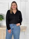 Miik model Christal (5'3", large) smiling wearing Miik's Lucia collared shirt in black and jeans