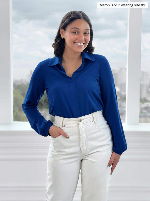 Miik model Meron (5'3", xsmall) smiling wearing Miik's Lucia collared shirt in ink blue with white jeans