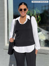 Miik model Meron (5'3", xsmall) smiling wearing Miik's Lucia collared shirt in white along with a black tank as a vest, black pants and a shoulder bag 