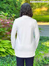 Miik model standing with her back towards the camera showing the back of Miik's Lucia collared shirt in white, original fit