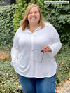 Miik model plus size Jen (5'2", size 4x) smiling wearing Miik's Lucia collared shirt in white with jeans 