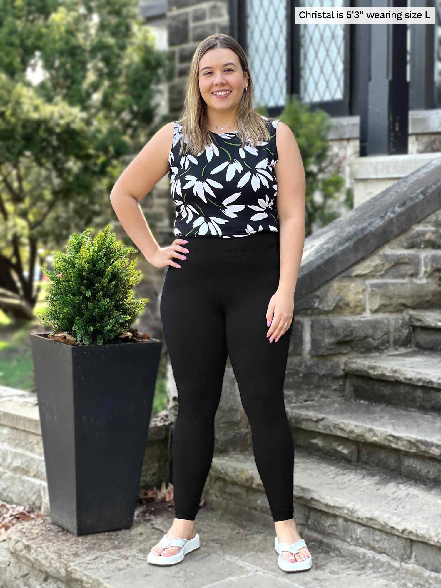 Free: woman wearing brown leggings standing near body of water