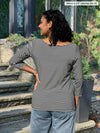 Miik model Meron (5’3”, xsmall) standing with her back towards the camera showing the back of Miik's Mahala boatneck breton top
