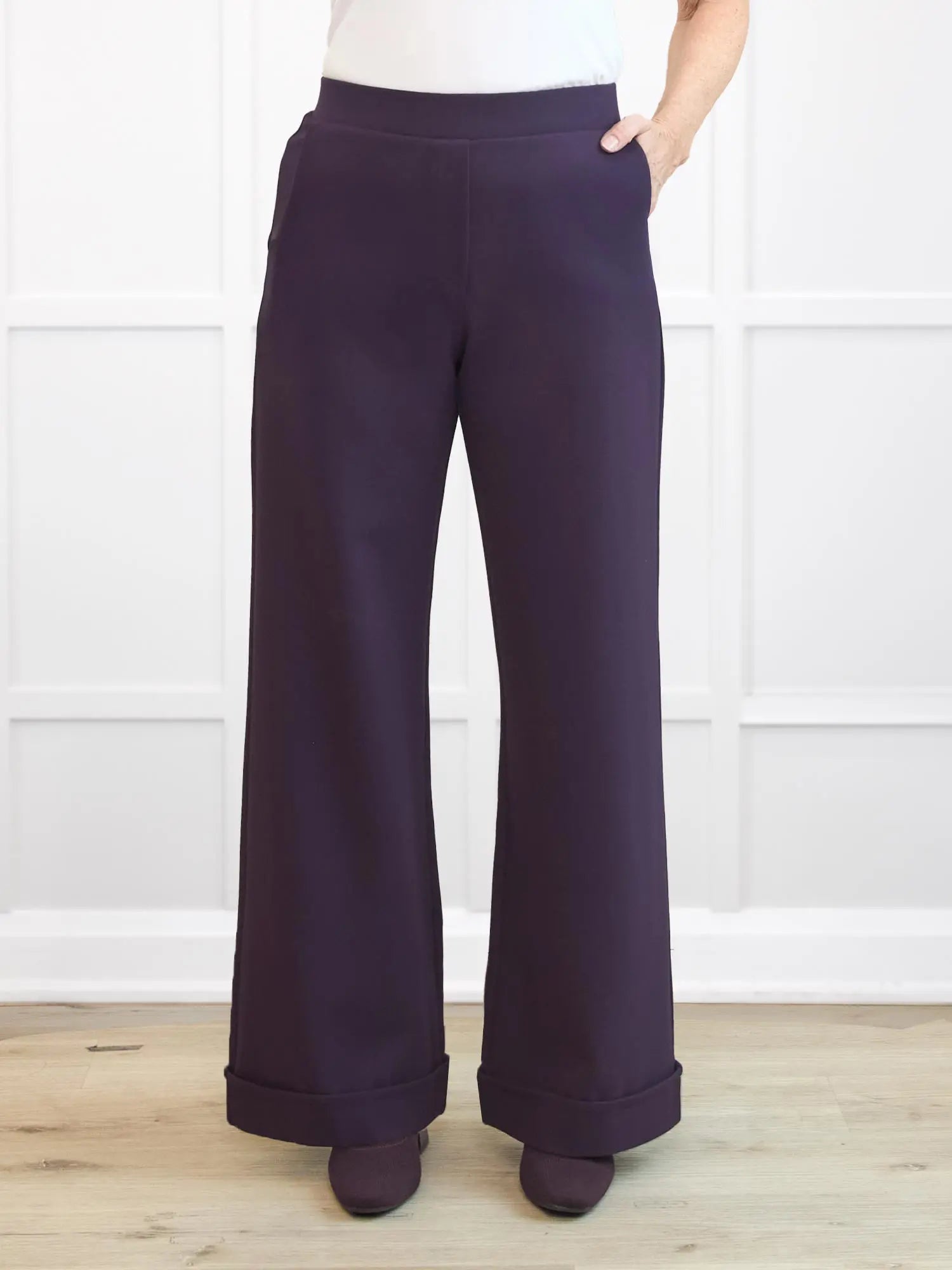 Purple wide-leg pants worn by a person on a white background