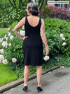 Miik founder Donna (five feet six, small) tanding with her back towards the camera showing the back of Miik's Maryse reversible sweetheart dress in black, when the sweetheart neckline is worn in the front and the scoop in the back