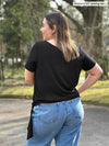 Miik model Christal (5’3”, large) standing with her back towards the camera showing the back of Miik's Melody side tie top 