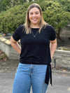 Miik model Christal (5'3", large) smiling wearing Miik's Melody side tie top in black with jeans 