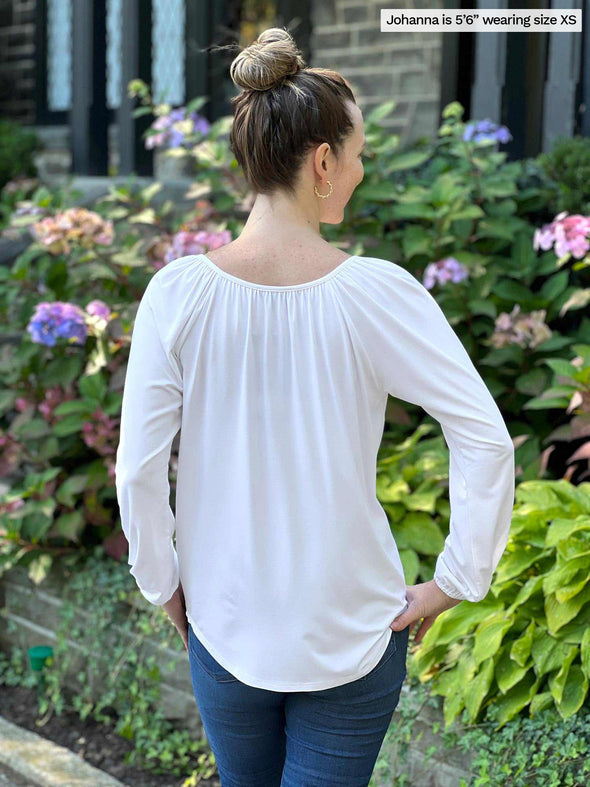 Woman standing with her back towards the camera wearing Miik's Mitchel long sleeve boho blouse in white with jeans.