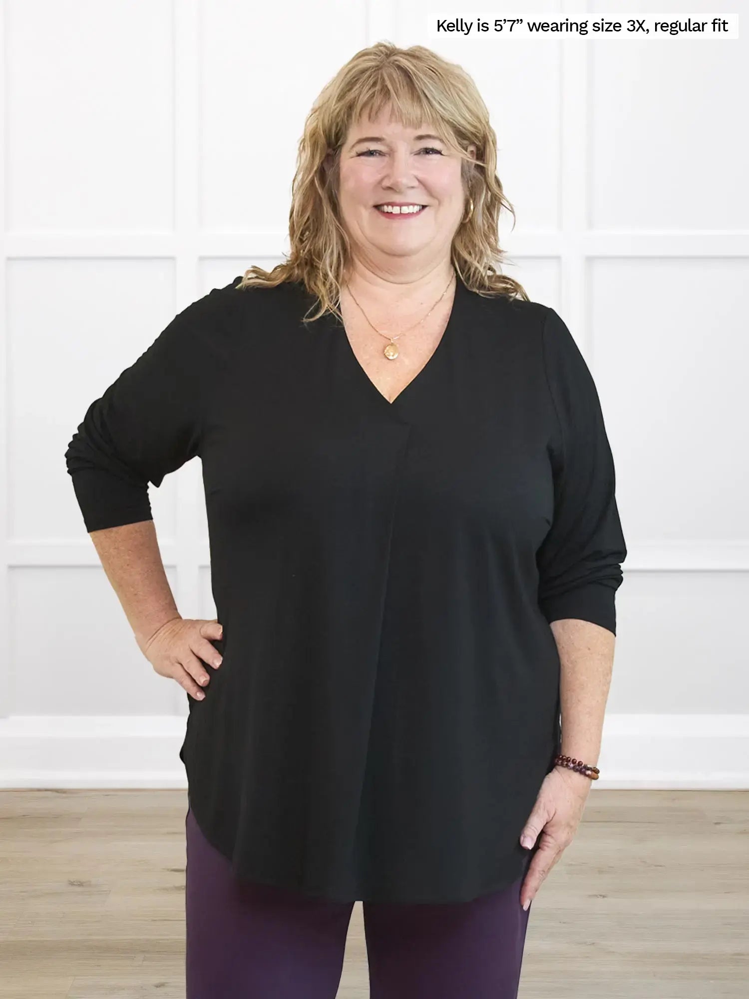 Woman wearing a black top with a white background 