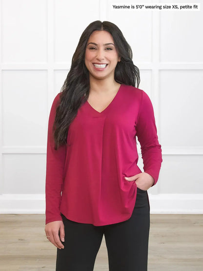 Woman wearing a red long-sleeve top against a white background 