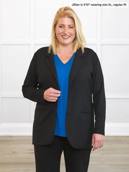 Woman wearing a black blazer over a blue shirt with text indicating size and fit information. 