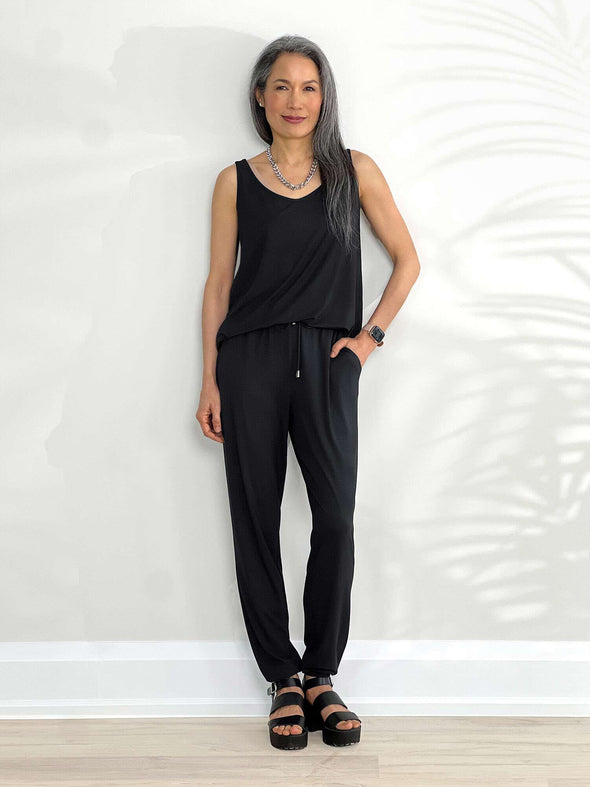 Miik model Lisa (5'6", xsmall) smiling wearing Miik's Perle open-back sleeveless jumpsuit in black 
