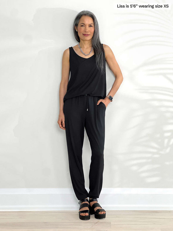 Miik model Lisa (5'6", xsmall) smiling wearing Miik's Perle open-back sleeveless jumpsuit in black