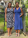 Miik models Raquel and Pat smiling standing next to each other both wearing Miik's RJ midi flounce dress with pockets in blossom print and blueberry