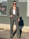 Woman standing in front of a building wearing Miik's Reed high waisted pant with pockets in grey stripe with a grey blazer and a white tank 