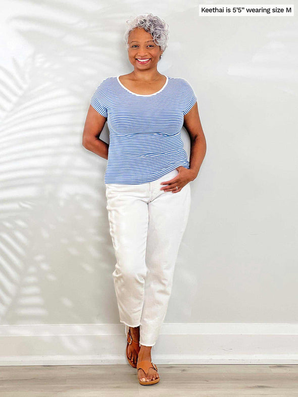 Miik model Keethai (5'5", medium) smiling wearing a white jeans with Miik's Rio reversible dolman tee in cobalt mini stripe 