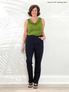 Miik founder Donna (5'6", small) smiling while wearing Miik's Roma pull-on straight leg ankle pant in black with a green moss top