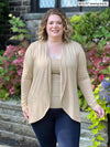 Miik model Bri (size XL, 5 foot 5) wearing the Rory waterfall cardigan in beige camel melange layered over a matching tank and navy leggings.