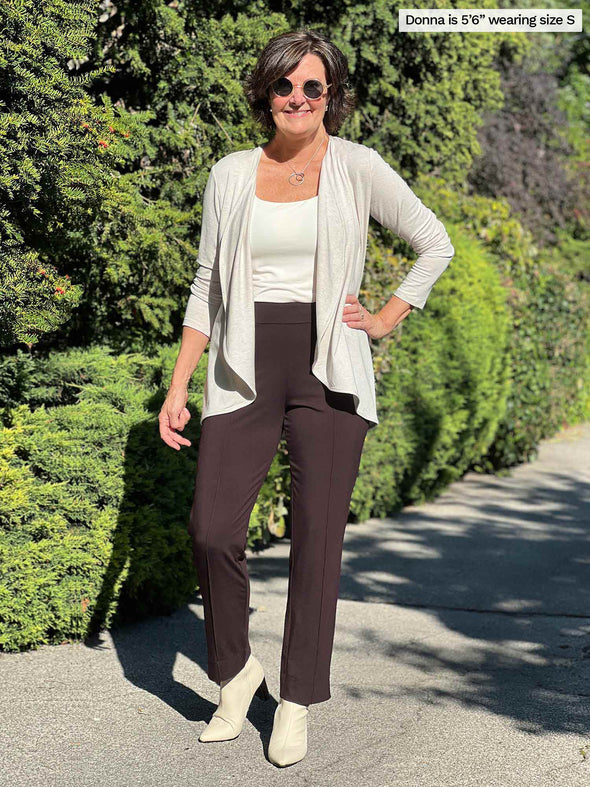 Miik founder Donna (size S, 5 foot 6) wearing the Rory waterfall cardigan in off-white oatmeal with the matching Amina tank underneath, tucked into chocolate brown pants.