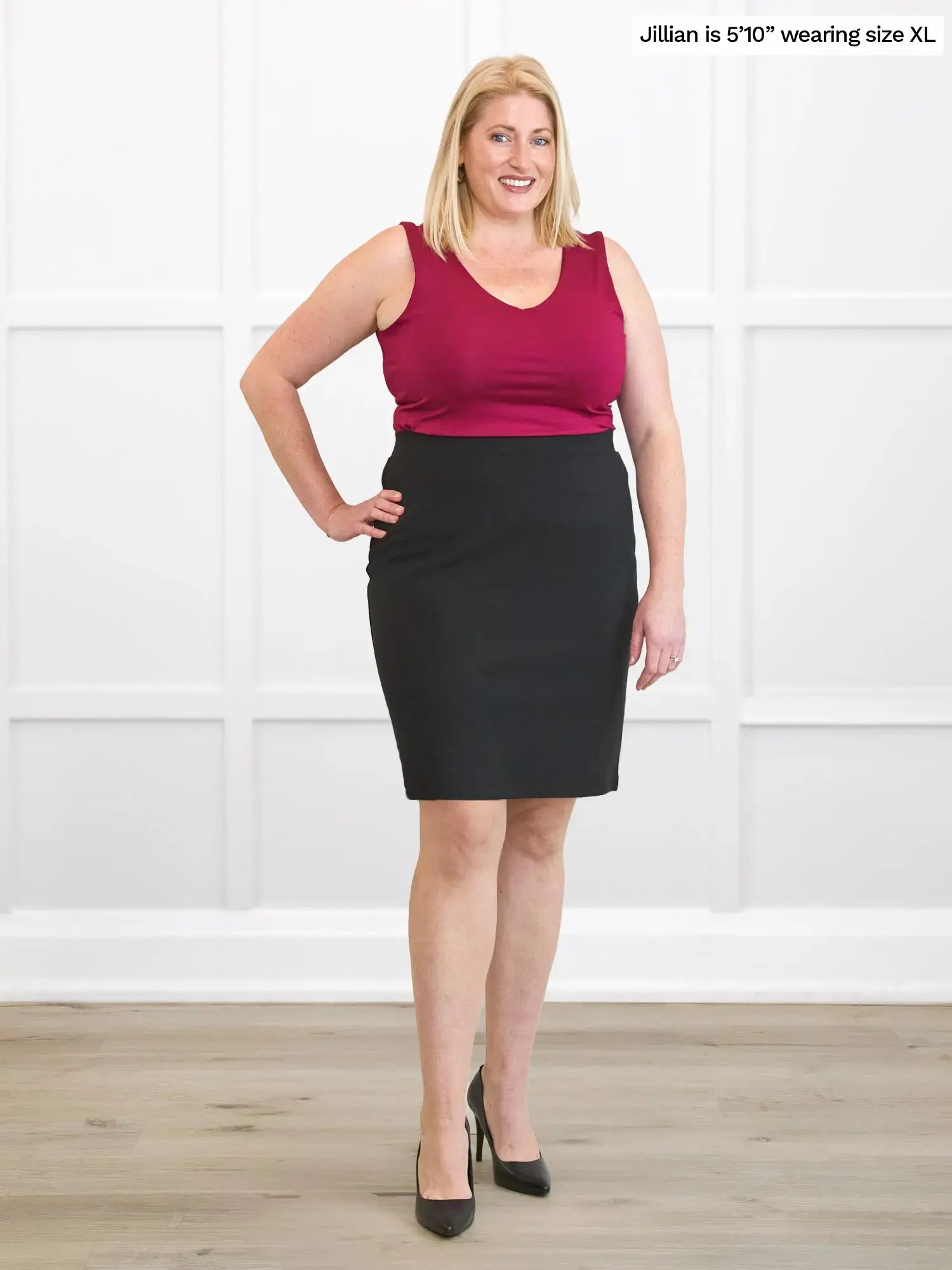 Woman wearing a red top and black skirt against a white background 