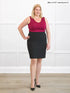 Woman wearing a red top and black skirt against a white background 