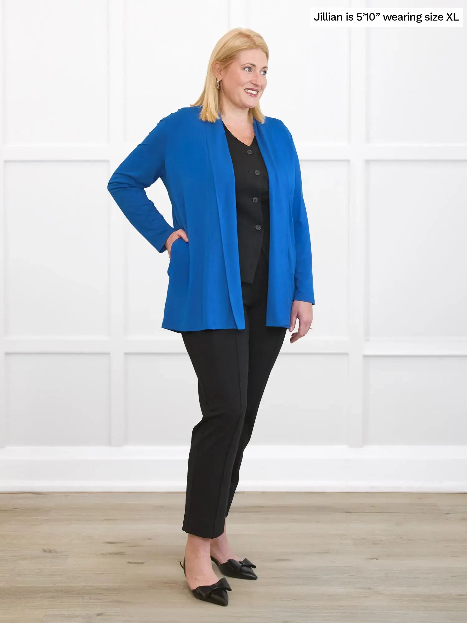 Woman wearing a blue jacket and black pants on a white background 