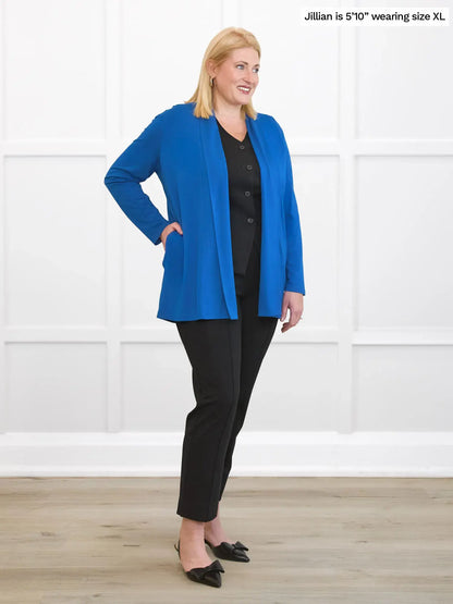 Woman wearing a blue jacket and black pants on a white background 