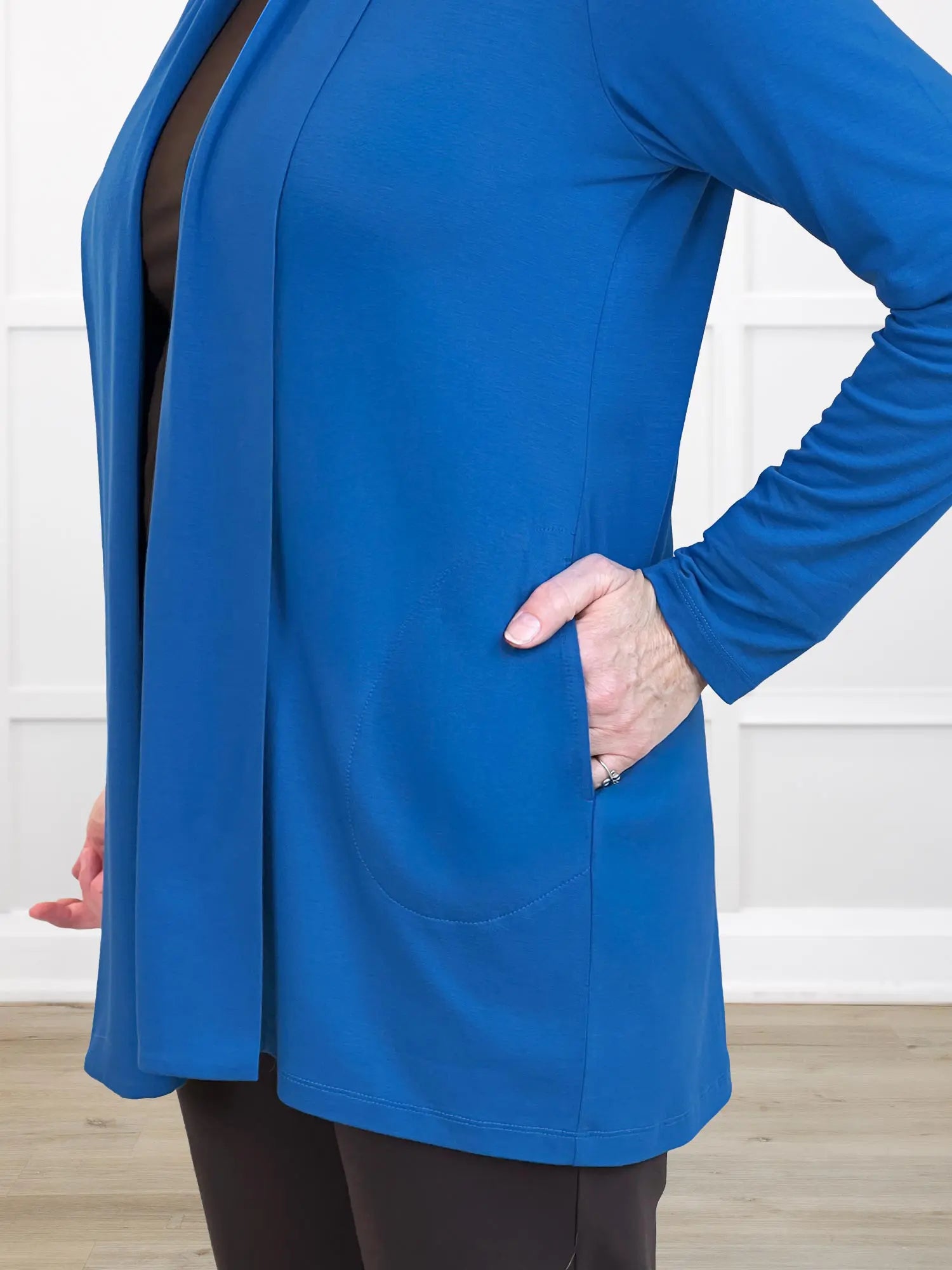 Person wearing a blue cardigan with a white background 