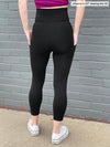 Close up of the back of Miik's Seana high waisted pocket capri legging in black.