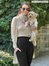 Miik model Johanna (5'6", xsmall) smiling while holding a puppy wearing Miik's Seana high waisted pocket legging in black with a tank and cardigan with pockets in the camel melange colour