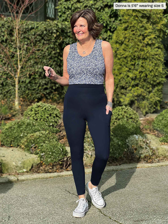 Miik founder Donna (5'6", small) smiling and looking away wearing Miik's Seana high waisted pocket legging in navy with a tank top in baby's breath 