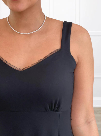 A close-up of the bust and neckline details on the Seville sweetheart midi dress, showing the ruffled neckline and straps. 