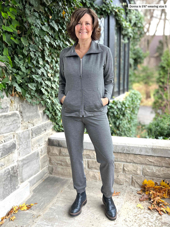 Miik founder Donna (5'6", small) smiling wearing a matching fleece set in granite melange with boots. Donna is wearing Miik's Shaelyn full zip luxe fleece jacket along with the Linaya jogger