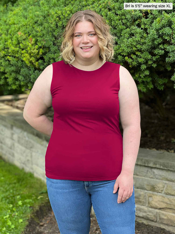 Miik model Bri (size XL, five foot five) wearing Shandra reversible tank top in bordeaux red, with the high neck in front.