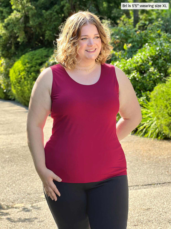 Miik model Bri (size XL, five foot five) wearing Shandra reversible tank top in bordeaux red, with the scoop neck in front.