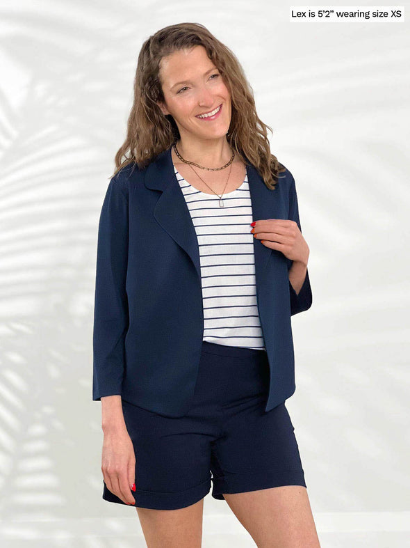 Miik model Lex (5'2", xsmall) smiling wearing Miik's Shandra reversible tank top - coastal stripe with a navy short and a cropped blazer in the same colour