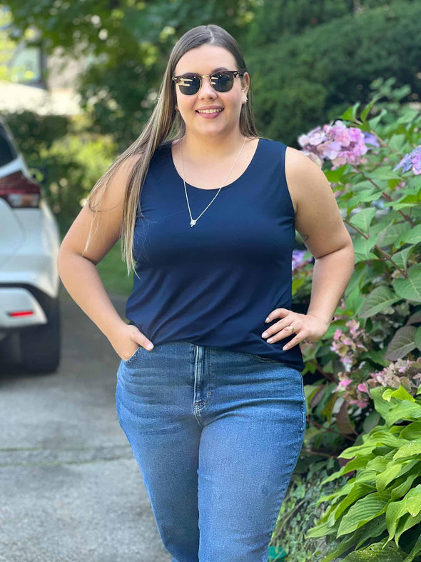 Miik model Christal (size L, five foot three) wearing Shandra reversible tank top in navy blue, with the scoop neck in front.
