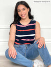 Woman sitting down wearing Miik's Shandra reversible tank top in navy white and pink stripe with jeans.