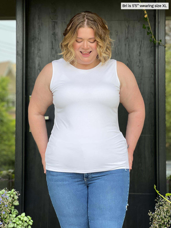 Miik model Bri (size XL, five foot five) wearing Shandra reversible tank top in white, reversed with the high neck in front.