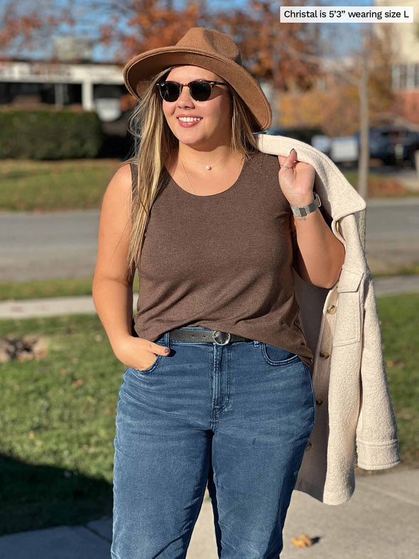 Miik model Christal (5'3", large) smiling and looking away wearing Miik's Shandra reversible tank top in chocolate melange along with jeans and a shaket over her shoulders 
